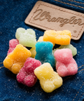 Colorful Sugar Daddies gummy bears scattered on denim with Wranglers leather patch - altitude adjusting gummies