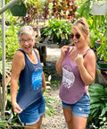 Two women standing in a garden center, surrounded by plants and gardening supplies.