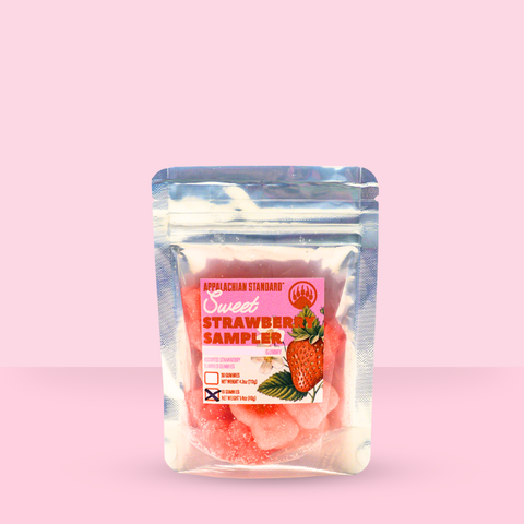 Packaged strawberry product with a pink label on a pink background