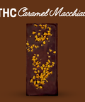 Chocolate bar with caramel pieces on a brown background, labeled 'THC Caramel Macchiato'.