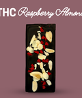 Dark chocolate bar with raspberry and almond pieces on a purple background, labeled 'THC Raspberry Almond'.