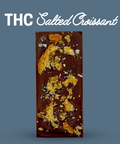 Chocolate bar with salted croissant pieces on a blue background, labeled 'THC Salted Croissant'.