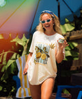 Woman standing under blue umbrella in cream lemon shirt with blue headband on
