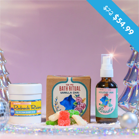 A photo of Appalachian Standards Mrs. Clauses Spa-La-La-La-La Bundle featuring the perfect way to unwind. Starting with their Limited Edition Christmas CBD Boujee Bears and Holiday Inn Paradise Body Oil. Perfectly paired with their best selling Vanilla Chai Bath Bomb and Redneck Riviera Body Cream. The products are surrounded by shiny glass decor Christmas trees, and disco balls.