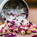 Rose petals, bath salts, chamomile flowers, and lavender spilled out of an 8 oz tin of Appalachian Standard's CBD Botanical Dream Bath Soak