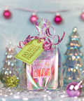 Gift bag with a tag and ribbons against a festive background with Christmas trees and lights.