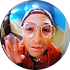 A circular button badge featuring a portrait of a person in a blue and white patterned headscarf, set against a plain white background.