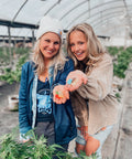 Lauren Davis, of Fiddy Shades of Green, and her mom stand smiling in a greenhouse while holding Boujee Bear CBD Gummies