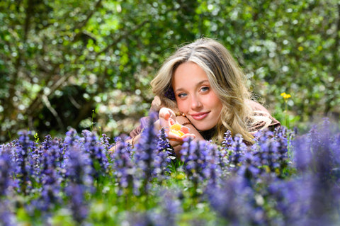 Lauren holding gummies in a field of purple flowers
