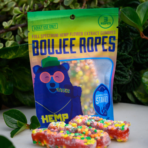 Nerds Rope CBD Candy in packaging in front of leaves and surrounded by moss. 