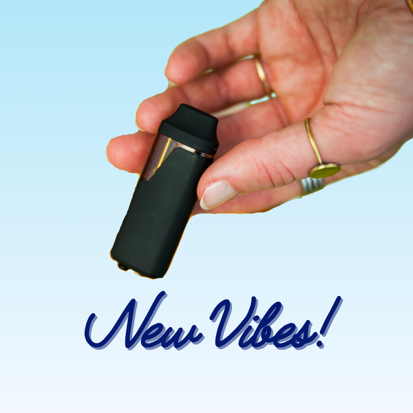 A hand holding a black vibe vessel with a light blue background and the words "New Vibes" in cursive blue at the bottom