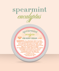 Appalachian Standard Spearmint Eucalyptus CBD Body Cream tin, 188mg, 1.5 oz, displayed on a soft peach background. The round tin features a cream and coral label with a daisy pattern.