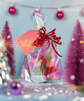 Gift bag with a 'From Santa' tag in front of Christmas trees and decorations