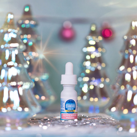 Bottle of peppermint extract with a blurred festive background
