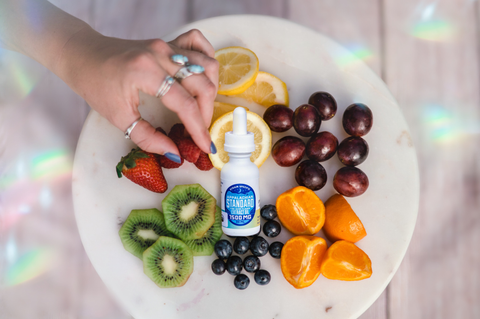 A bottle of Appalachian Standard's Tutti Frutti CBD Tincture surrounded by fruit